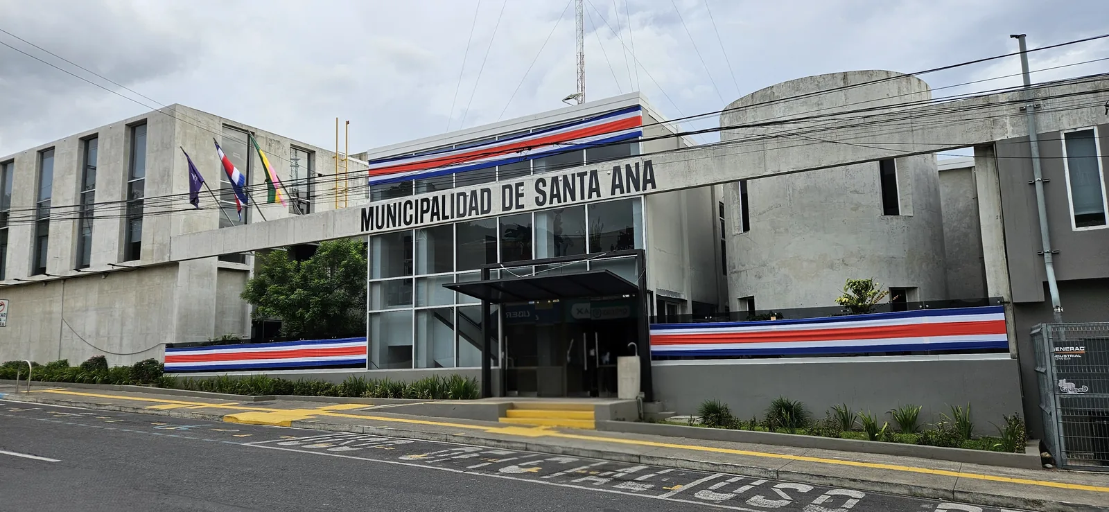 Fachada del edificio de la Municipalidad de Santa Ana, adornada con franjas azul, blanco y rojo de la bandera de Costa Rica.
